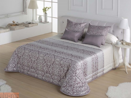 Conjunta los textiles del dormitorio con cojines estampados y lisos y cortinas a juego