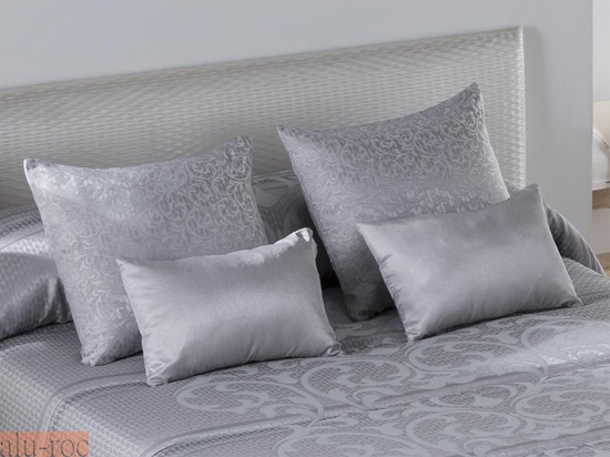 Vestir la cama del dormitorio con cojines de diferentes tamaños, formas y estampados